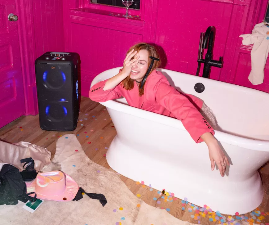 klipsch_party_speakers_vibe_woman_laughing_sleepily_fully_clothed_in_a_bathtub_2000x1670.webp